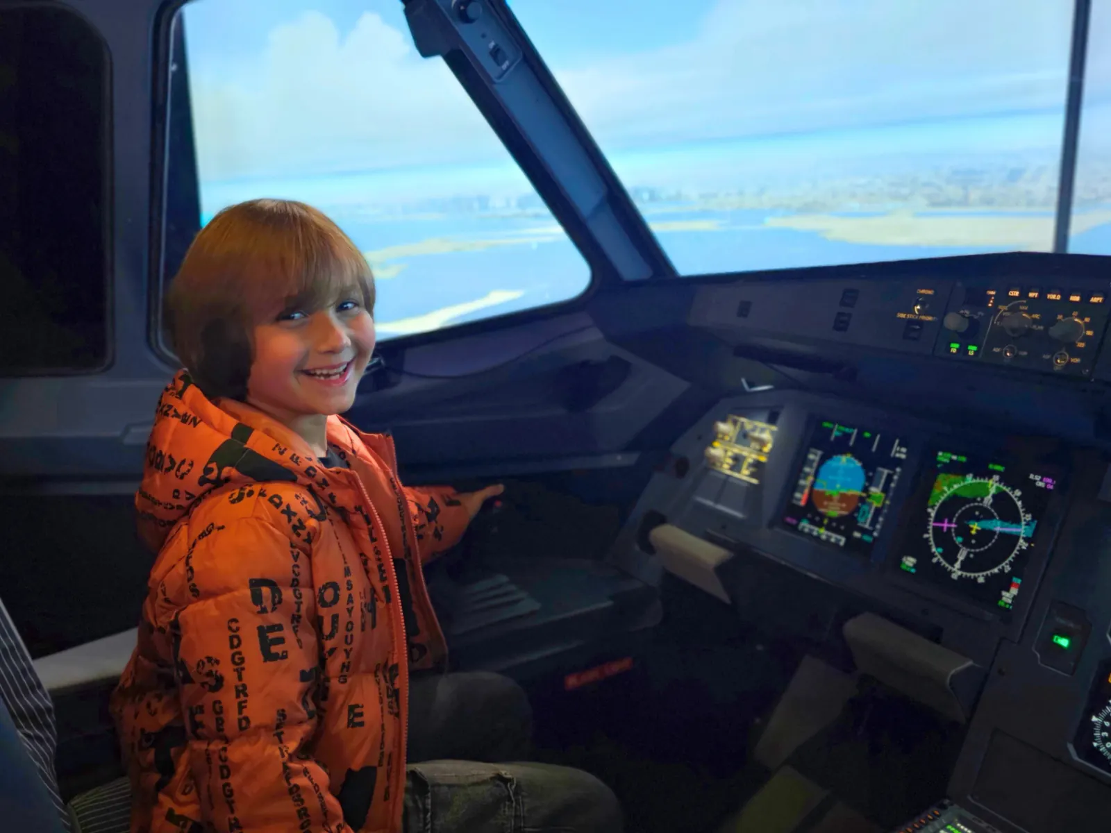Child enjoying a flight simulator cockpit session
